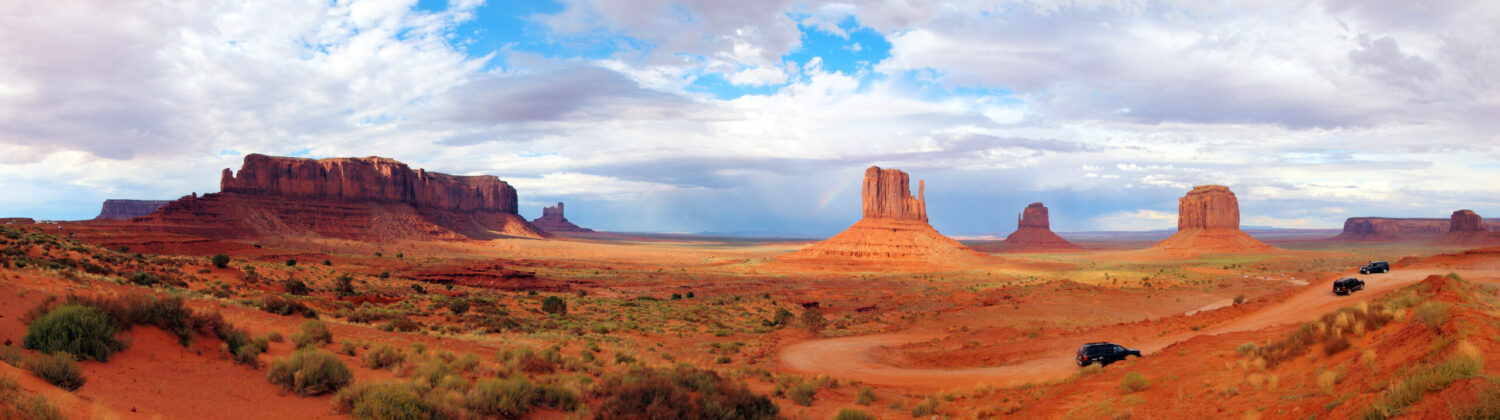 Panoramic winter view of Monument Valley in Arizona and Utah, United States — a globally recognised travel destination. Ideal image to represent air ambulance repatriation from the USA to the UK, with snow-covered desert monoliths under sunset light.