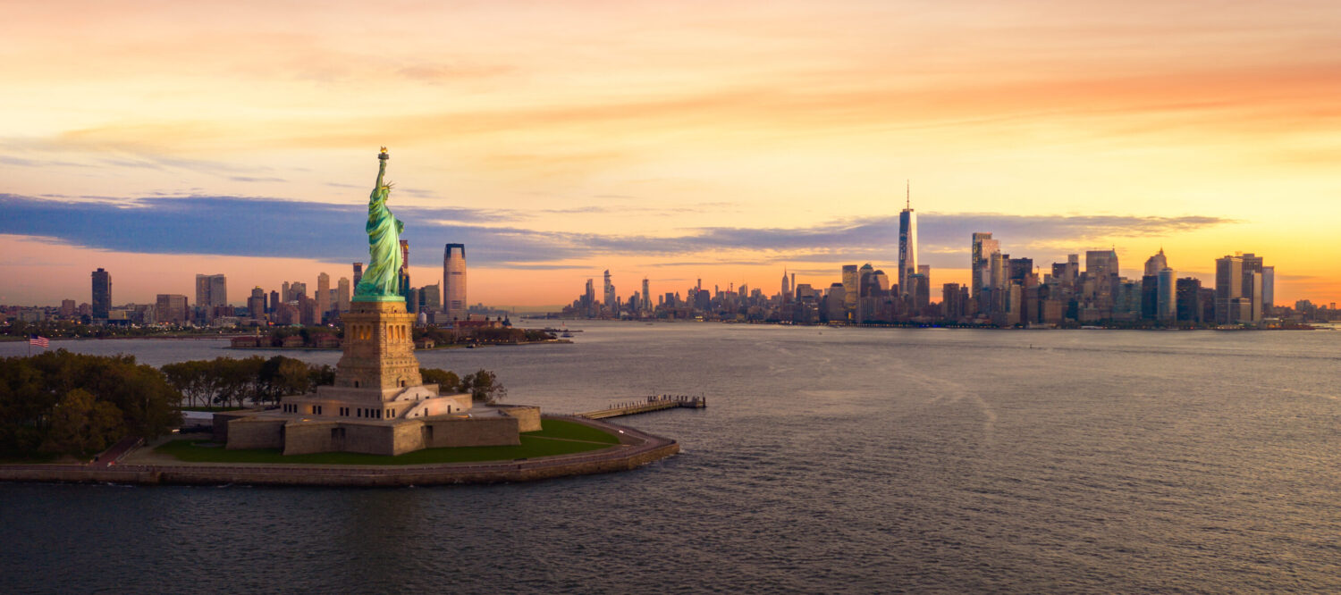 Statue of Liberty and Manhattan skyline at sunset, symbolising SkyCare’s medevac and air ambulance services from New York to the UK.