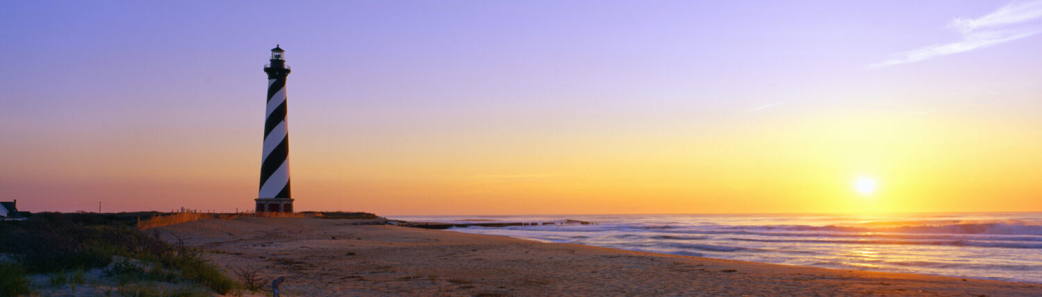 Air ambulance flying over Cape Hatteras Lighthouse in North Carolina, symbolising emergency medical repatriation services