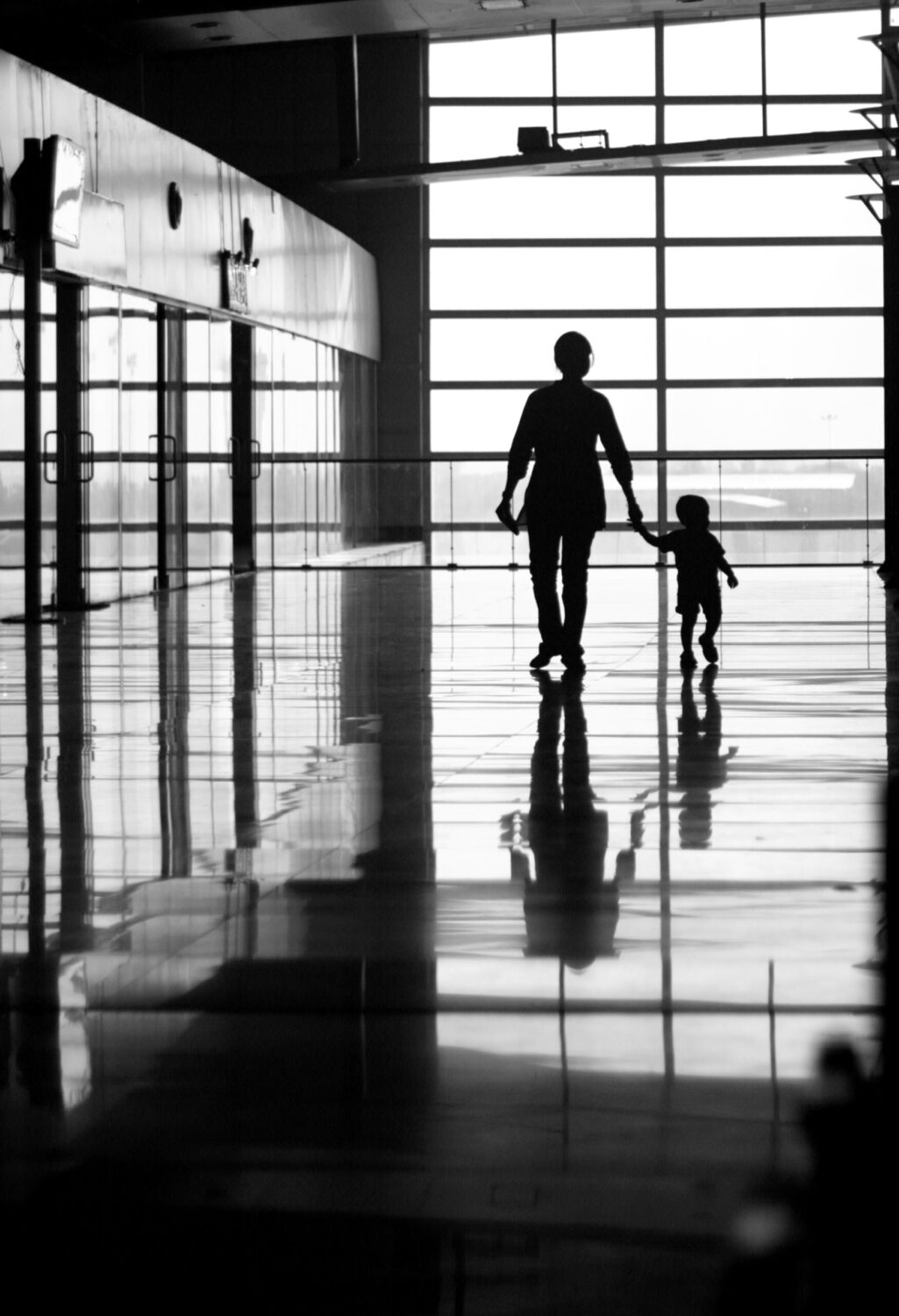 Medical escort guiding child traveler through airport terminal for supervised flight