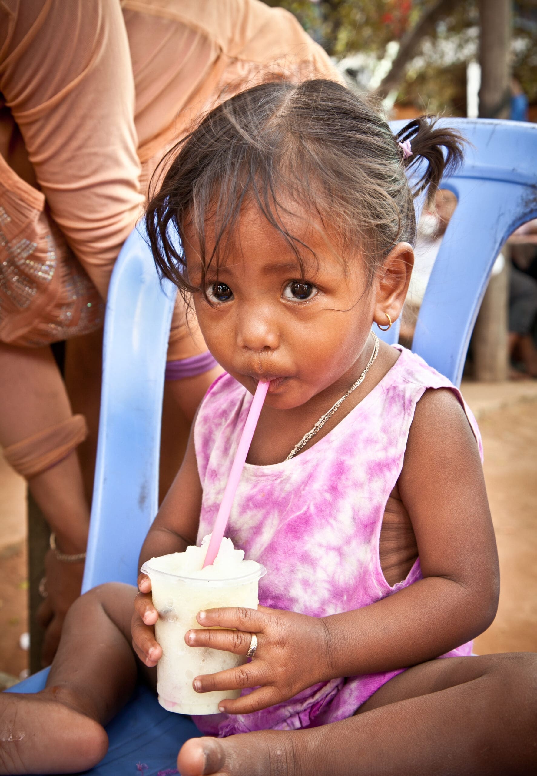 Child drinking clean water in Cambodia supported through climate action funding